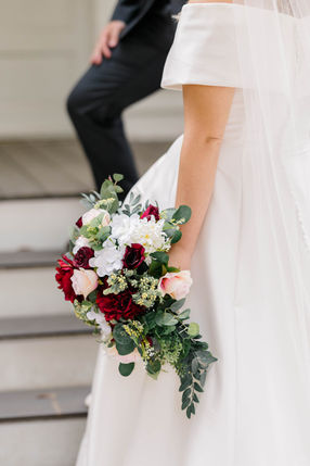 Fall cascading wedding bridal bouquet with red, white, and greenery. Designed by Dream Designs and Company