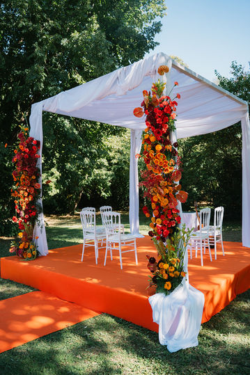 Décoration de mariage orange, drapée de blanc