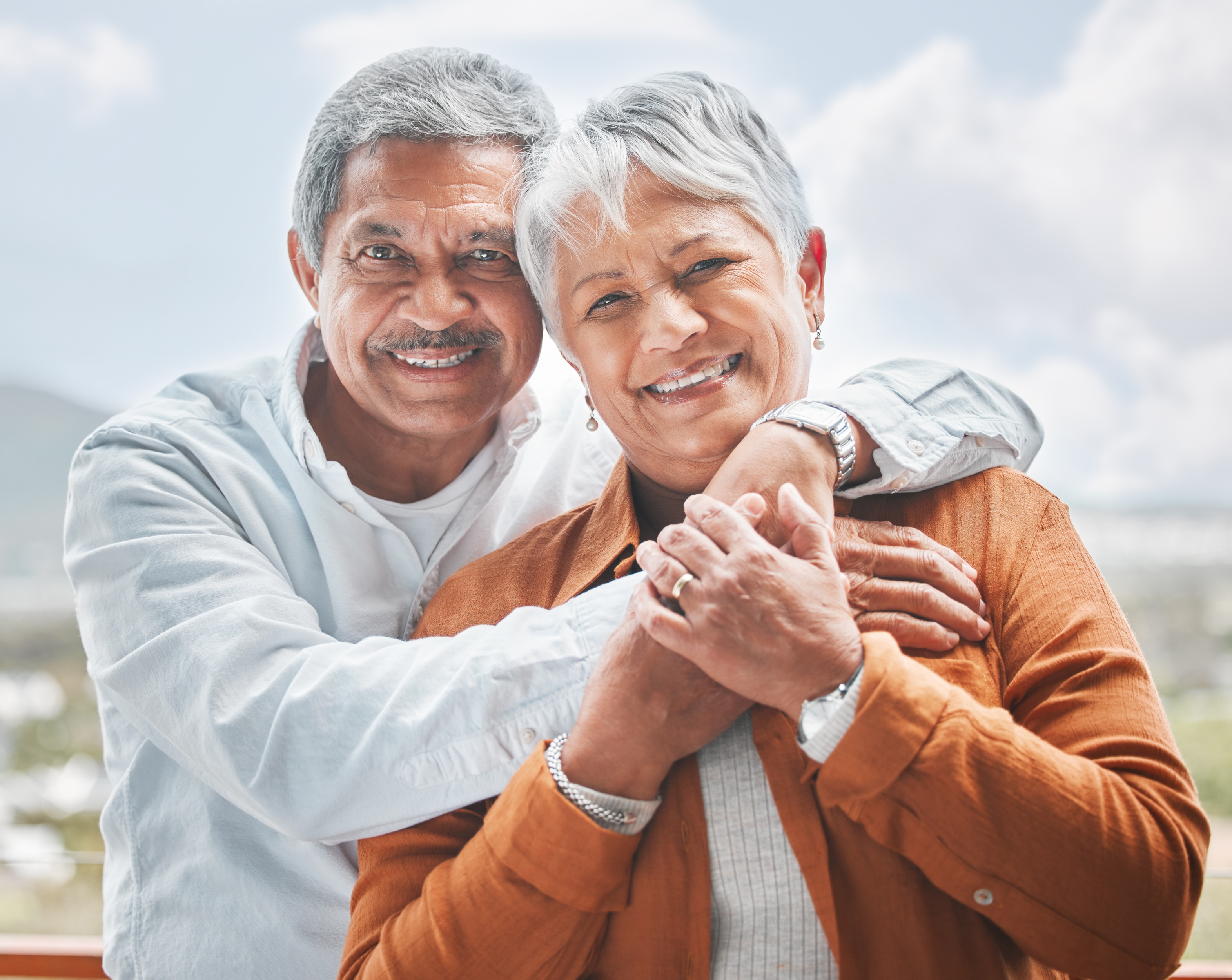 senior-couple-outdoor-portrait-with-smile-love-embrace-balcony-retirement-holiday-elderly-