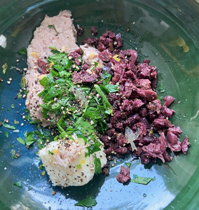 bowl with tuna, butter, chopped olives, parsley, lemon, salt, and pepper