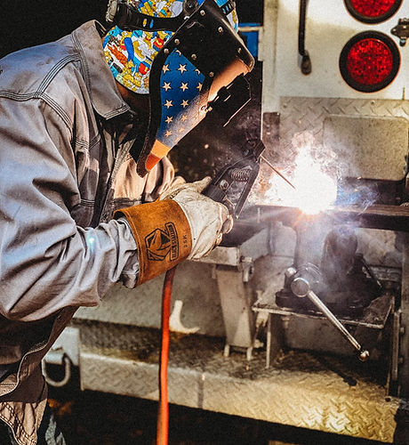 Mobile welding service performing on-site industrial steel welding from a work truck.