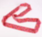 Pink floral patterned fabric laid in loops on a white background