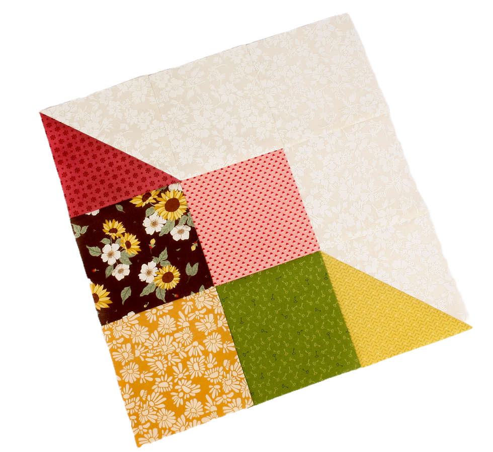 Colorful patchwork quilt square with floral and patterned fabric pieces on a black background