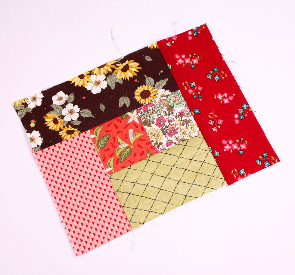 Patchwork quilt square of colorful floral and patterned fabric pieces on a white background, no text, handmade craft feel