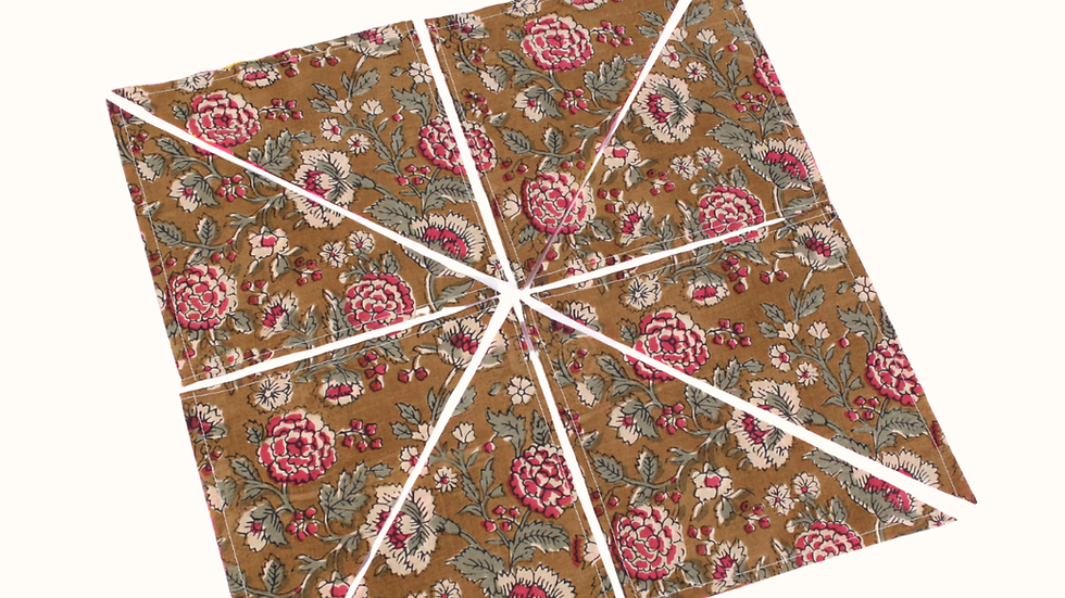 Fabric with floral pattern is cut into triangles. Text instructs to "cut along the drawn lines" and "cut diagonally." Rotary cutter illustration.
