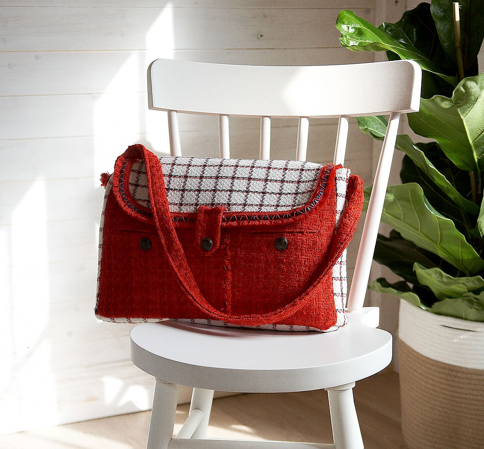 Thumbnail: a red upcycled bag made from old jackets on a white wooden chair in front of a plant