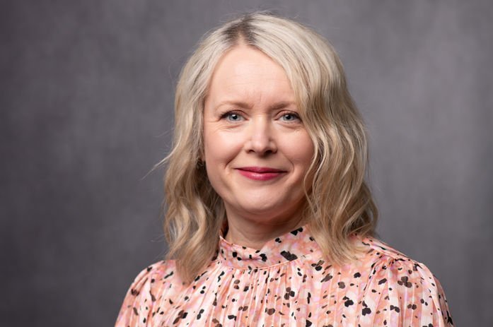 Accountant business owner poses for her headshot on a backdrop in Tunbridge Wells