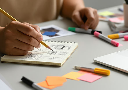vecteezy_person-sketching-building-designs-on-notepad-with-markers_73784934.jpg