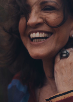 Atriz sorrindo para o horizonte.