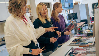 Three women reviewing artwork at Cavan Institute’s Open Day