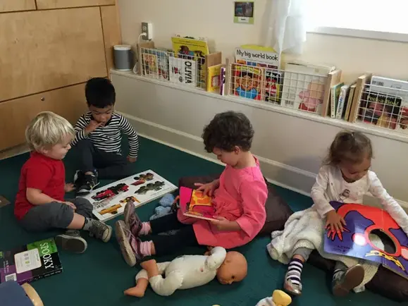 Two-year-olds looking at books together in the reading corner