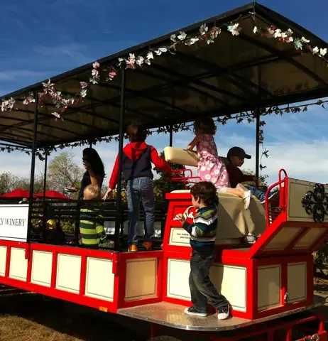 Preschoolers riding a decorated miniature train during a festive community celebration