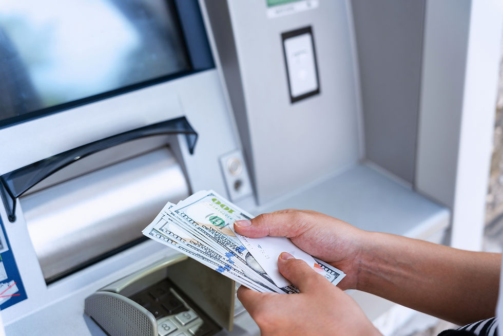 Customer withdrawing cash from an ATM - Close-up of a hand holding dollar bills at an ATM machine, showcasing AccessATM's free ATM services for businesses