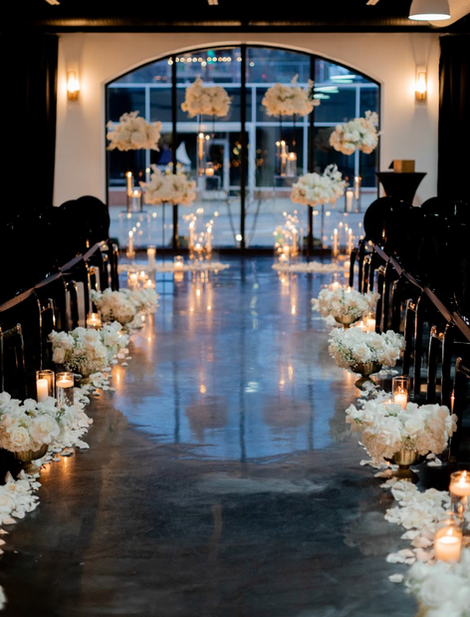 The Maverick Elegant wedding aisle with flowers and candles.