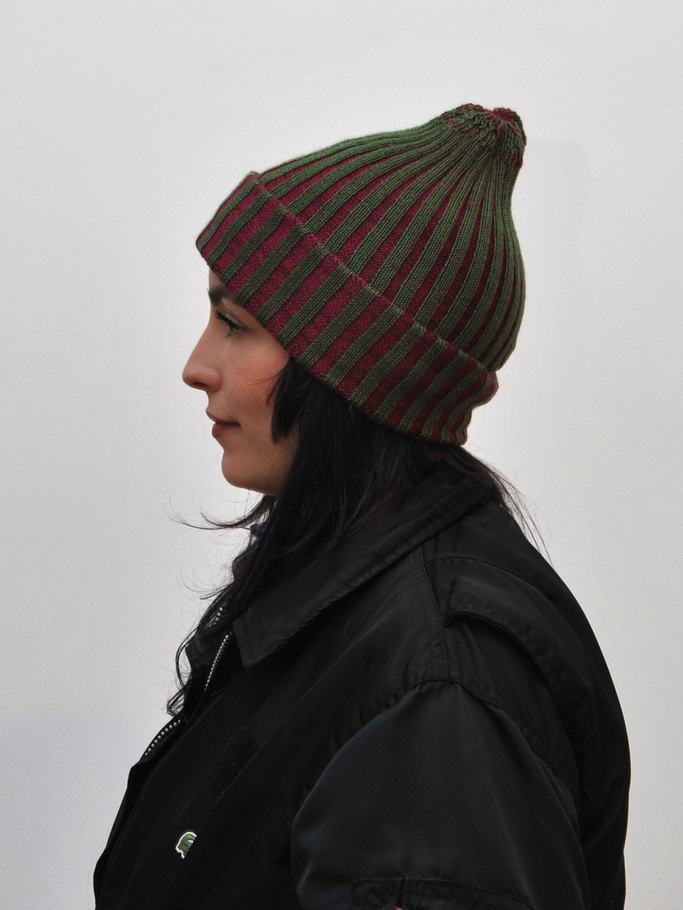 Knitted beanie crafted from repurposed luxury materials, showcasing sustainable fashion design.