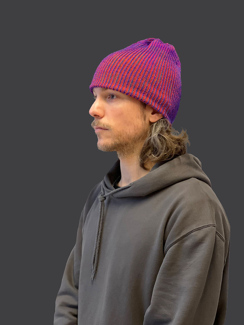 Knitted beanie crafted from repurposed luxury materials, showcasing sustainable fashion design.