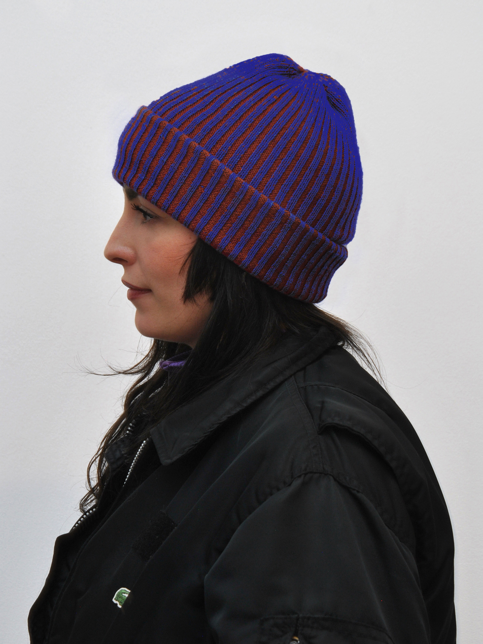 Knitted beanie crafted from repurposed luxury materials, showcasing sustainable fashion design.
