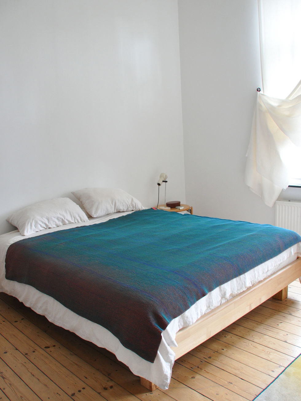 Red and blue variation, seen as blue, blanket flat on a bed