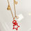Thumbnail: gold and red charm lanyard