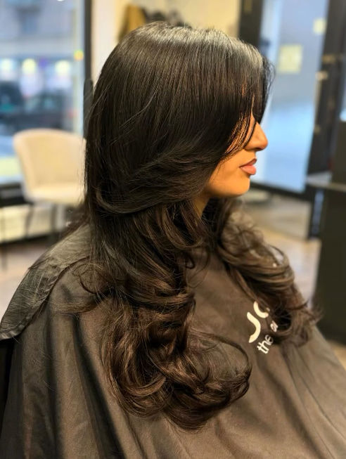 Voluminøse krøller hos frisør i Oslo – En elegant frisyre med store, naturlige krøller, perfekt for deg som vil ha fylde og b