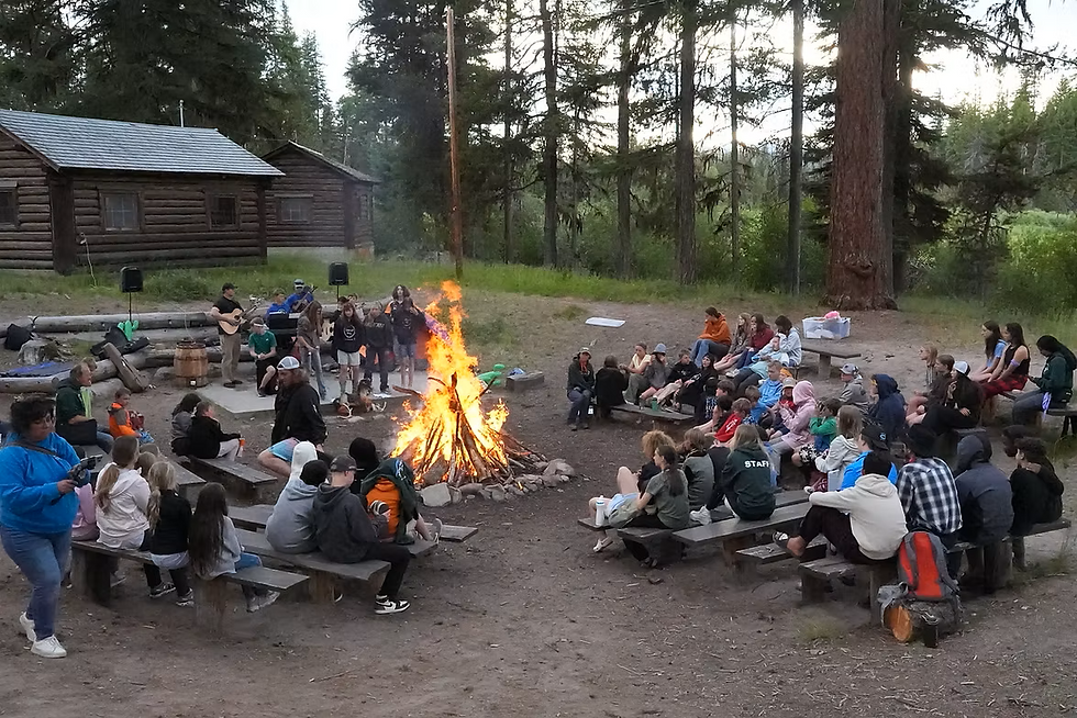 Youth around the campfire at youth camp 2025