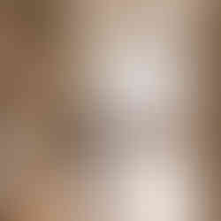 badkamer met natuurlijke materialen zoals terrazzo vloer, houten wastafel en vrijstaand bad in een lichte modern klassieke ruimte met dakraam en zachte tinten