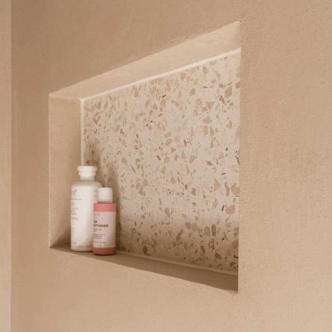 Badkamer nis met terrazzo en lichte wanden in klassieke woning.