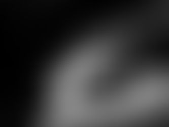 Man leaning forward over a counter with papers, cartons, and a drink can in a dim interior workspace, photographed by Gary PWK for the Made In His Image project.