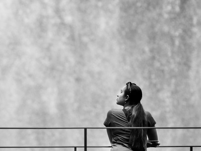 Person standing quietly before the Jewel indoor waterfall in Singapore, symbolising reflection on forgiveness, healing, and the inner work that remains after letting go.