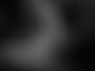 Black and white urban street scene showing a solitary man resting in a narrow alleyway at night under harsh lighting, representing unnoticed strength and everyday human resilience.