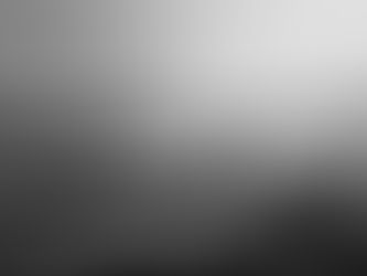 A solitary person seated by the sea, facing the horizon in quiet stillness.