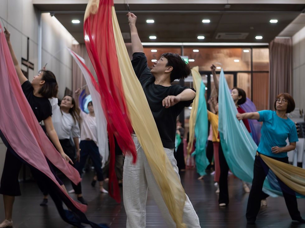 Elaine Chan and a group of dancers practicing with long fabric flags in a studio, multiple participants moving together, photographed by Gary PWK for the Made In His Image project.