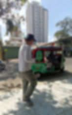 David approaches a green Grab tuk tuk in Phnom Penh, Cambodia.
