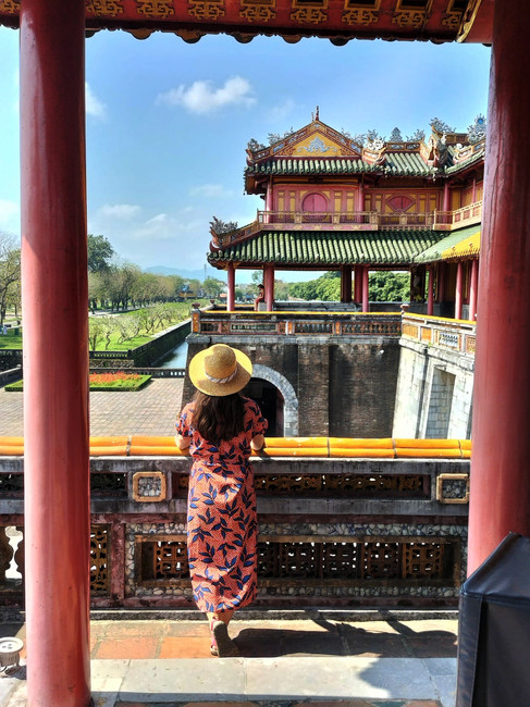 a woman in a red dress and straw sunset at Hue's Imperial Citadel