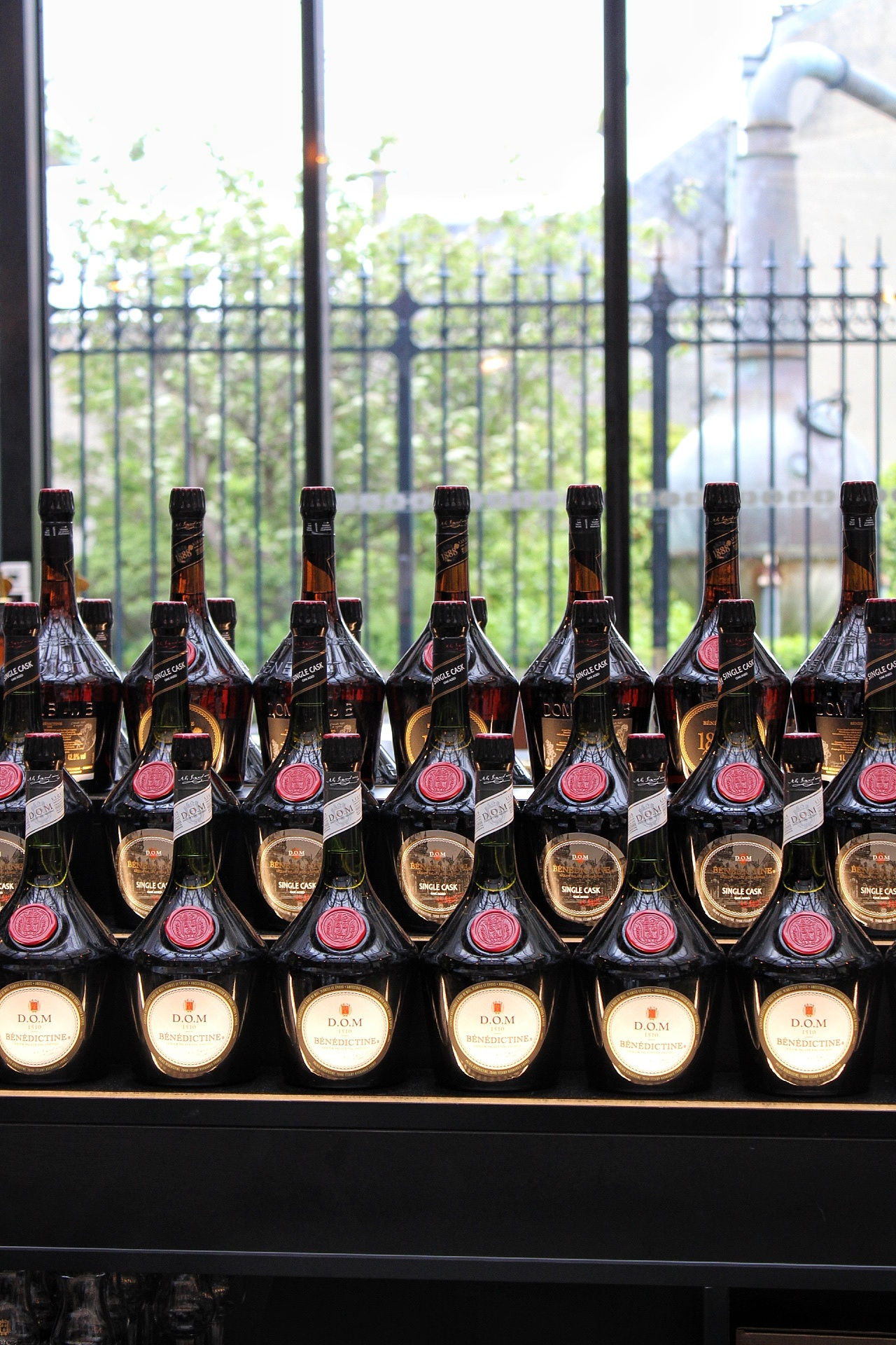 Bottles of Fecamp's famous Benedictine liqueur lined up on a bar.