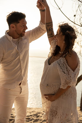 Couple enceinte dansant sur la plage