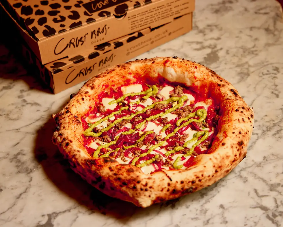 Pizza with Harissa Tomato, Mozzarella, Spiced Lamb or Roasted Aubergine, Whipped Feta, Pistachios, Pomegranate Seeds, Zhoug, Aleppo Butter.