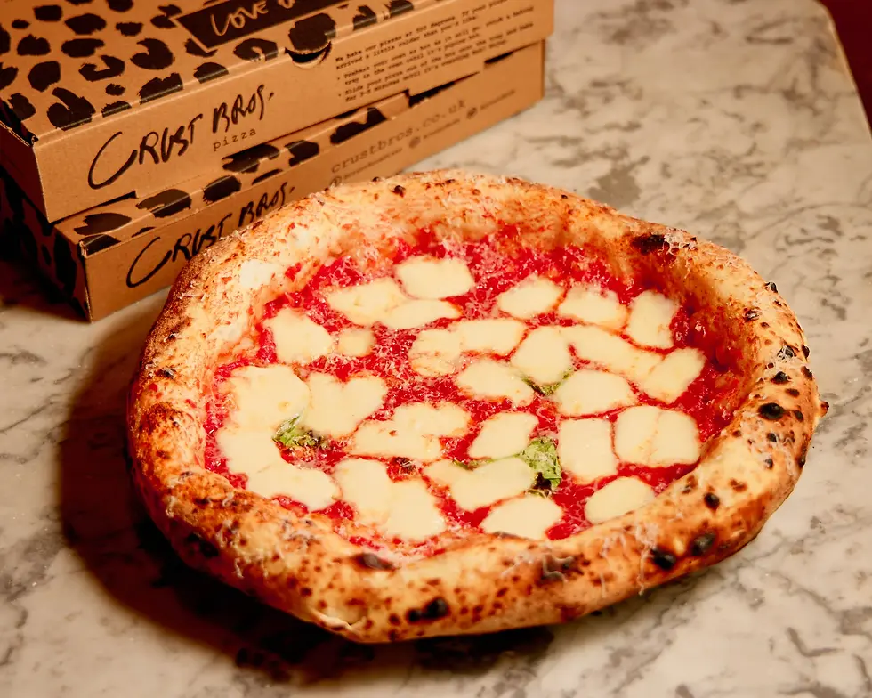Margherita pizza topped with tomato sauce, mozzarella, basil, and parmesan.