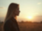 A woman looks for answers in the distance as the sun sets behind her.