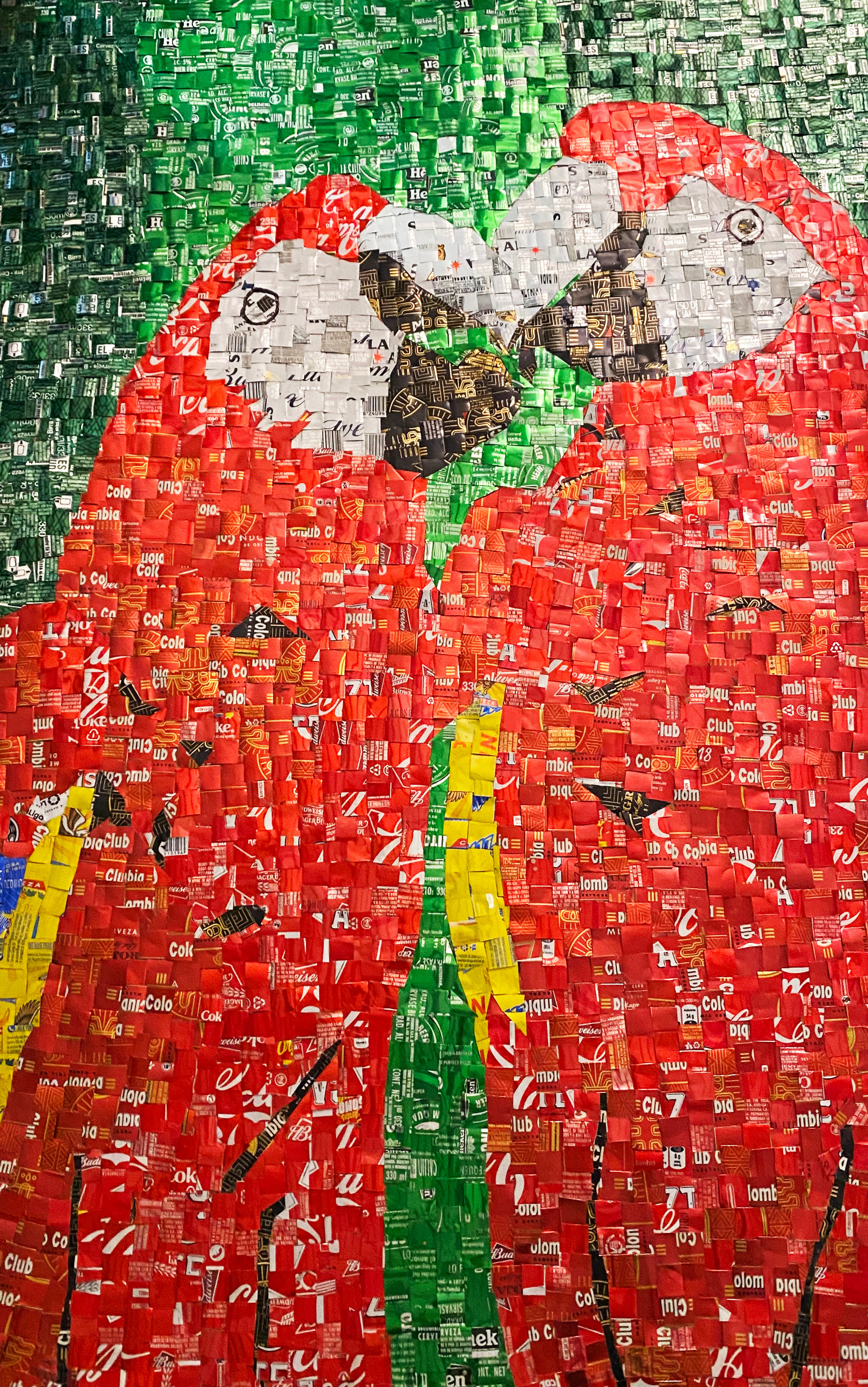 Dos loros rojos en mosaico de piezas recicladas