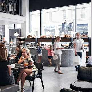 Interior of Ole & Steen bakery café in London with seating suitable for working on a laptop