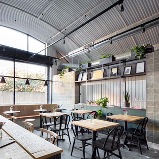 Spacious seating area at Origin Coffee London with large tables for remote work and meetings