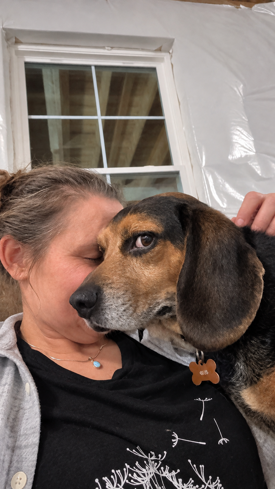 Woman cuddling a beagle.png