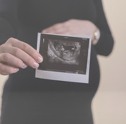 Cropped image of young pregnant woman holding ultrasound picture on belly._edited.jpg