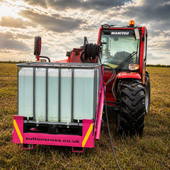 Suttons Hydraulic Wash System on a Manitou with quick hitch brackets in a field ready for use