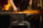 Hard work. Energy and power. Close-up working powerful hands of male blacksmith forge an i