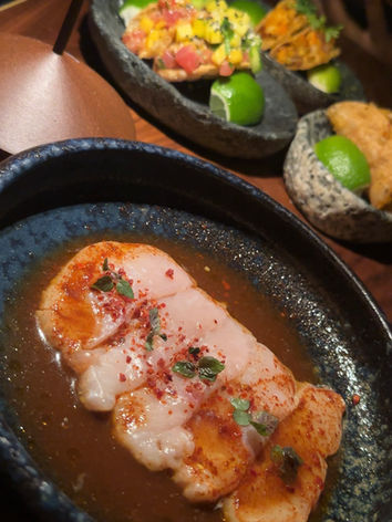 Seafood dishes served in black ceramic bowls