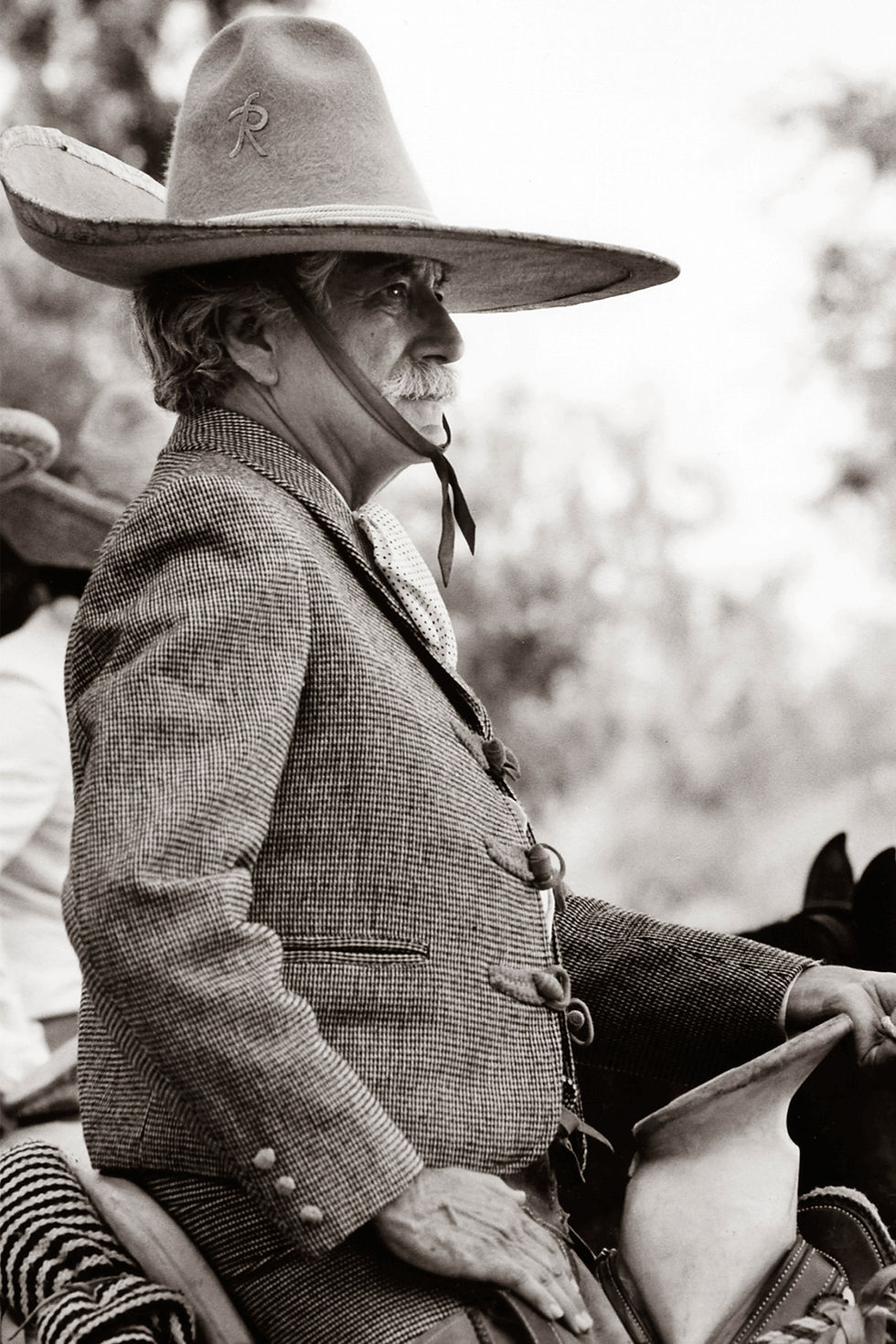A charro or Mexican cowboy sitting on a horse