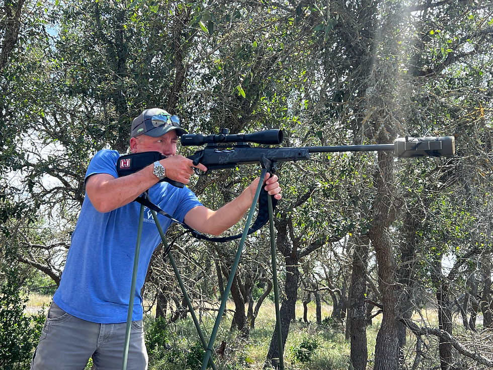 Wes Mundy practicing his shooting; he is standing and using a shooting stick