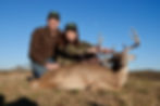 Two hunters, a man and a woman, with a trophy Texas Whitetail deer